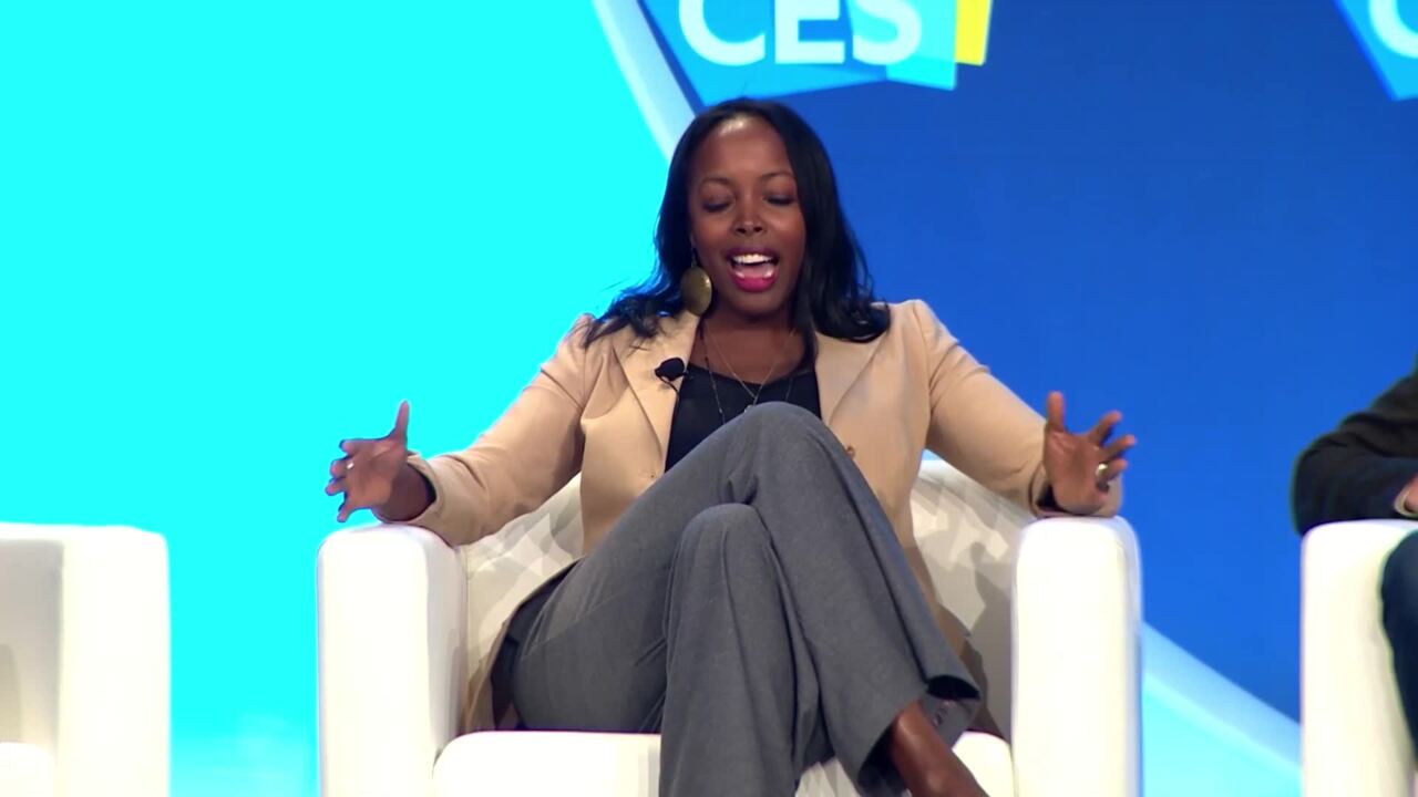 ALT Text: A woman sitting on stage talking about her work during CES